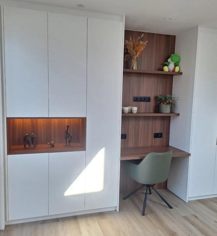 Bureau met wandplanken in notelaar tussen witte maatkasten